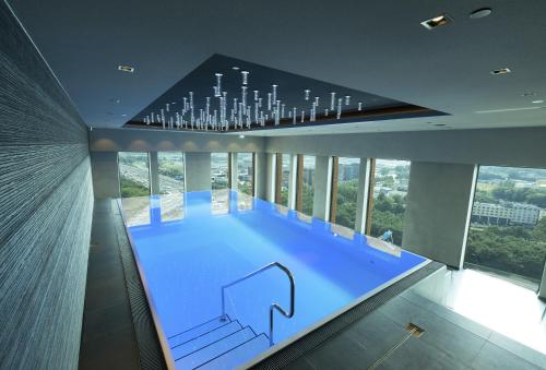 a large swimming pool in a building with a chandelier at Van der Valk Hotel Utrecht in Utrecht
