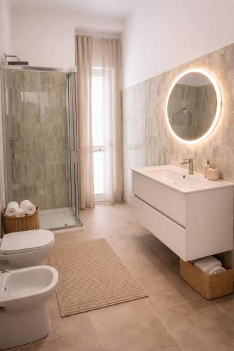 a bathroom with a sink and a toilet and a mirror at Tenuta Maison Angelina in Formia