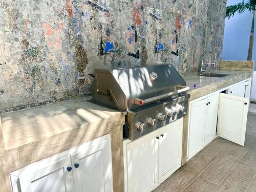 a kitchen with a grill on top of a counter at Downtown Chic Donde inicia la diversión en Punta Cana in Punta Cana