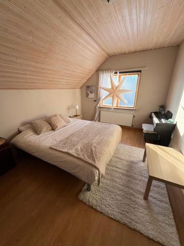 a bedroom with a large bed with a wooden ceiling at Boreal Cottage in Karungi