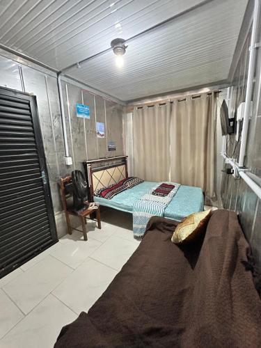 a small room with a bed and a chair at Mirante Itajubá in Barra Velha