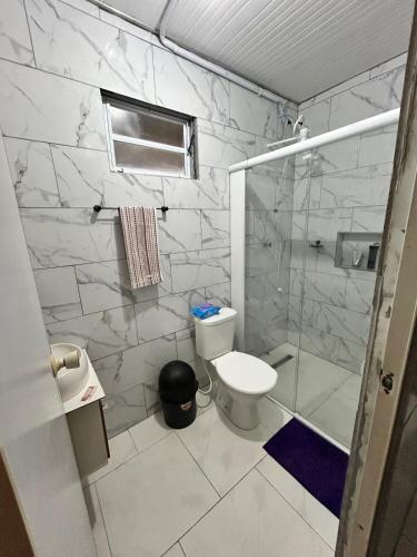 a bathroom with a toilet and a glass shower at Mirante Itajubá in Barra Velha