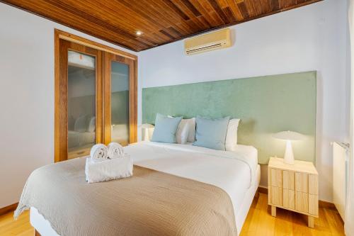 a bedroom with two beds with towels on top of them at Casa da Colina, By Home Match in Sesimbra