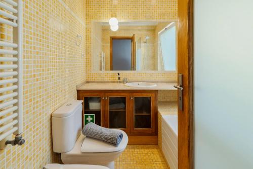 a bathroom with a toilet and a sink and a mirror at Casa da Colina, By Home Match in Sesimbra