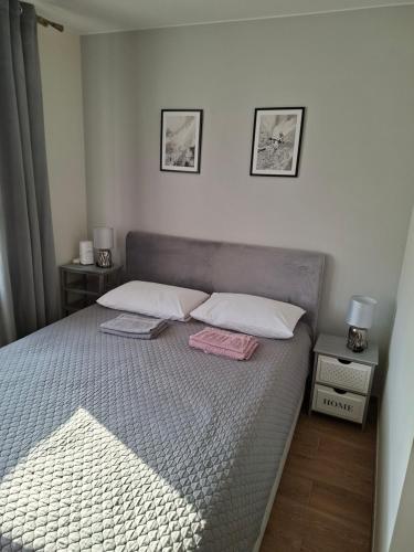 a bedroom with a bed with two pillows on it at Mieszkanko w centrum in Lidzbark Warmiński