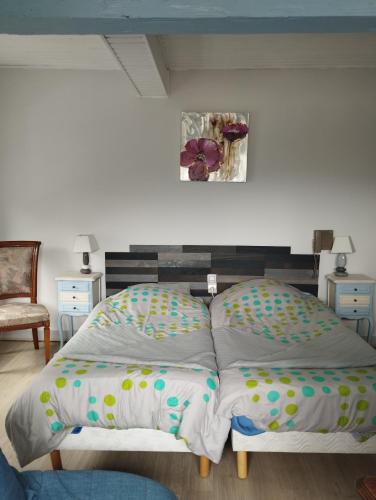 a bedroom with two twin beds and a picture on the wall at Le Kalblin in Fréland