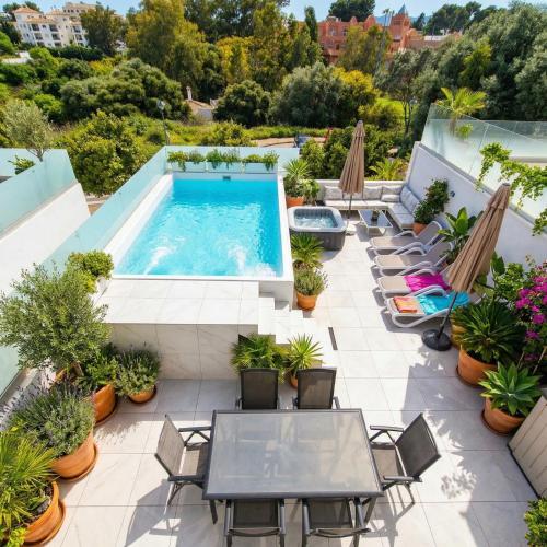 an outdoor patio with a pool and tables and chairs at Unique Villa Scandinavia Marbella in Marbella
