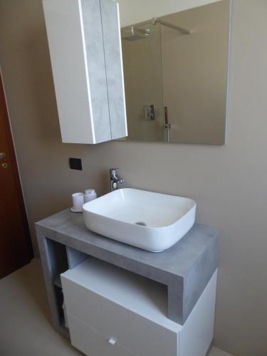 a bathroom with a white sink and a mirror at Casa Marta - tra vigne e motori in Castelvetro di Modena