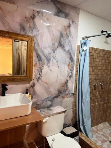a marble bathroom with a sink and a shower at Aloha.ayampe in Ayampe