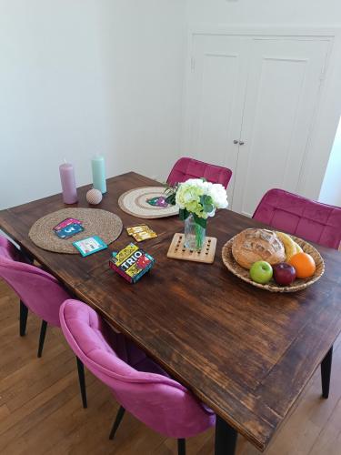 a wooden table with food and flowers on it at Le Refuge de la Tour in Calais
