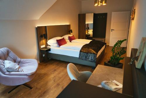 a hotel room with a bed and a chair at Residence Black Eagle Lubmin Strand in Lubmin