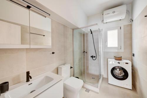 a bathroom with a toilet and a washing machine at VERSA by Apiro Syros in Ermoupoli