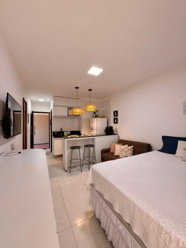 a large bedroom with a bed and a kitchen at Flat Ilhéus Olivença pé na areia no Condomínio Jubiaba in Ilhéus