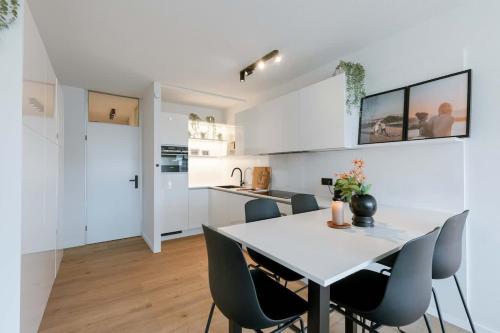 a kitchen and dining room with a table and chairs at Casiola - Nice apartment close to the beach with parking in Nieuwpoort