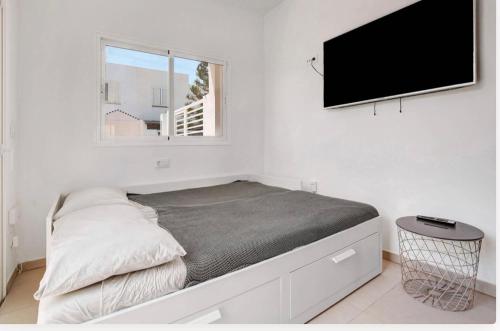a bedroom with a bed and a flat screen tv at Las Arenas in Costa Calma
