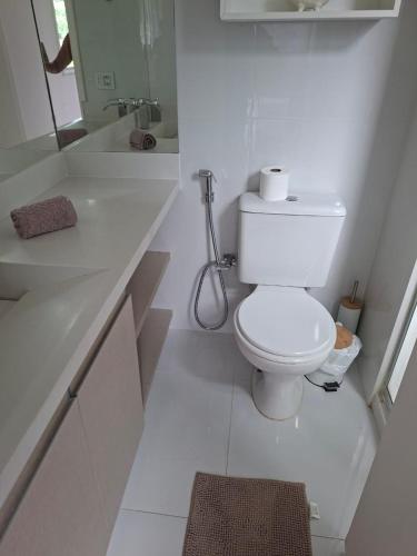 a white bathroom with a toilet and a sink at Porto Real Resort in Mangaratiba