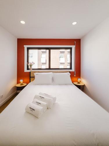 a bedroom with a large white bed with two towels at Chocolate House in Viana do Castelo