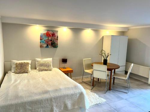a bedroom with a bed and a table and chairs at Pokoje w Kołobrzegu in Kołobrzeg