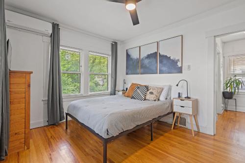 a bedroom with a bed and two windows at Entertainer - Brookside Walkable Firepit in Kansas City