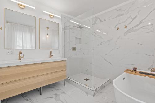 a bathroom with a shower and a tub and a sink at Entertainer - Brookside Walkable Firepit in Kansas City