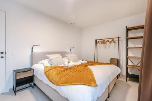 a bedroom with a large bed with a orange blanket at Casiola - Apartment with two large terraces in Zedelgem