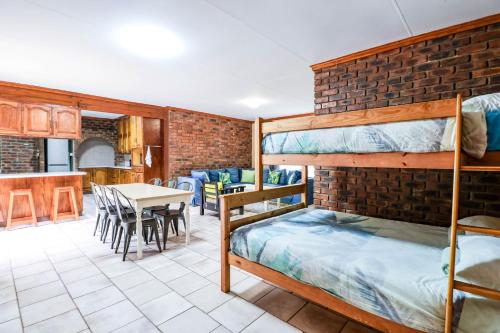 a room with two bunk beds and a table with chairs at Flamboyant Guesthouse in Bela-Bela