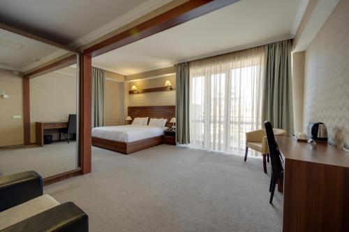 a hotel room with a bed and a desk at Hotel Astoria Tbilisi in Tbilisi City
