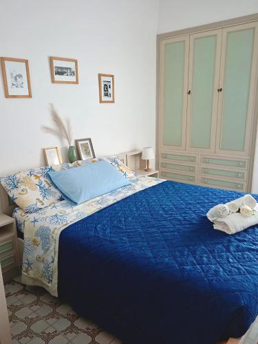 a bedroom with a blue bed with a blue comforter at Suite Fronte Mare Senigallia- Terrazza Esclusiva sulla Spiaggia in Senigallia