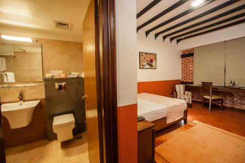 a room with a bathroom with a bed and a sink at Traditional Comfort Boutique Hotel in Kathmandu