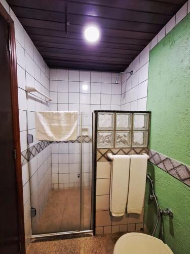 a bathroom with a shower with a toilet and towels at Pontal Tapes Hotel in Tapes