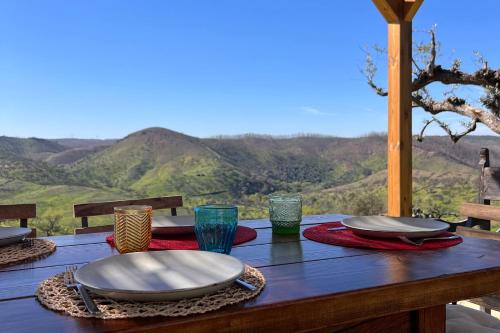 a wooden table with plates and napkins on a table with mountains at Casa da Vinagra in Pé da Serra