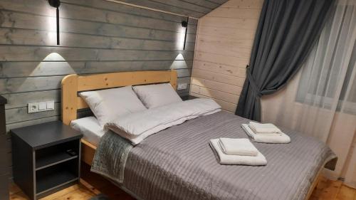 a bedroom with a bed with two towels on it at Garage Home in Yaremche