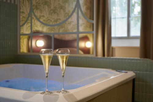 two champagne glasses sitting in a bath tub at Le Cocon Spa proche Puy DuFou in Mesnard-la-Barotière