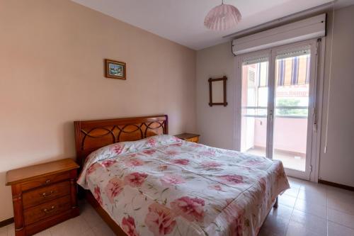 a bedroom with a bed with a floral bedspread at Casa Turistica Andora in Marina di Andora