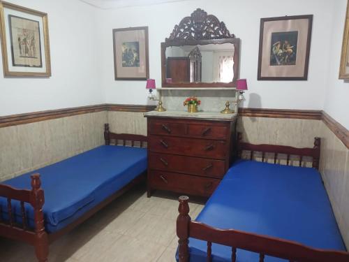 two beds in a room with a mirror and a dresser at Casa estilo colonial próximo Paço Municipal in Goiânia