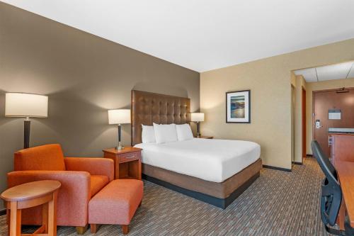 a hotel room with a bed and a chair at Drury Inn & Suites Fort Myers Airport FGCU in Fort Myers
