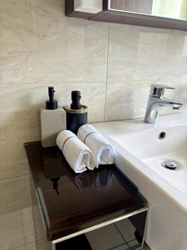 a bathroom with a sink and two towels on a counter at The Calm Corner in Trevallyn