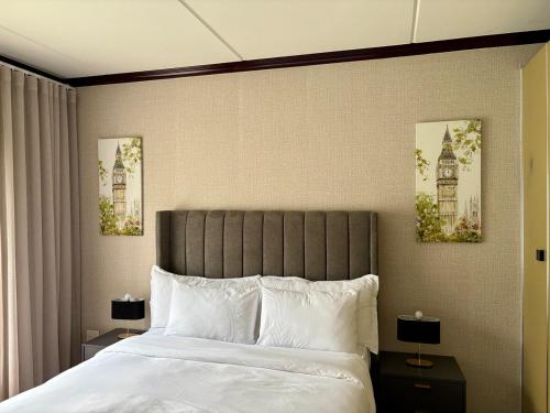 a bedroom with a large bed with two pictures on the wall at The Calm Corner in Trevallyn