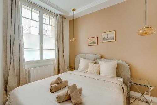 a bedroom with a bed with two stuffed animals on it at Saint mandé Place du marché in Saint-Mandé