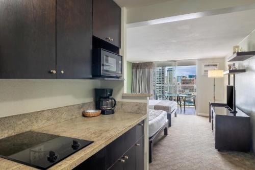 a kitchen with a counter top in a room at Skyline Island Colony Hotel in Honolulu