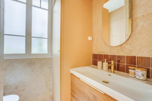 a bathroom with a sink and a mirror at Saint mandé Place du marché in Saint-Mandé