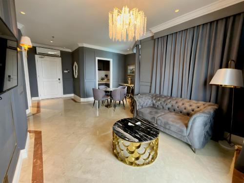 a living room with a couch and a table at Grand Eska Hotel & Suites Batam in Nagoya