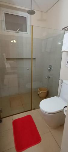 a bathroom with a toilet and a red rug at Shirley Pico de Loro 1BR in Nasugbu