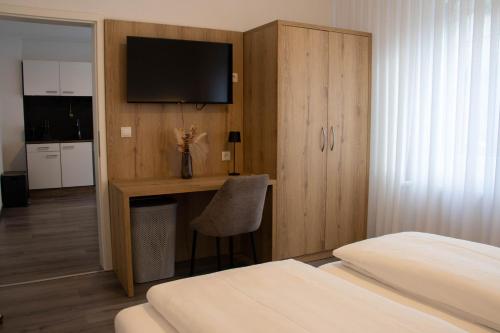 a bedroom with a bed and a desk with a television at Apartments-Altenahr in Altenahr