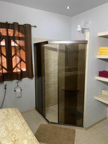 a shower with a glass door in a bathroom at Taverna do Paraiso in Janga
