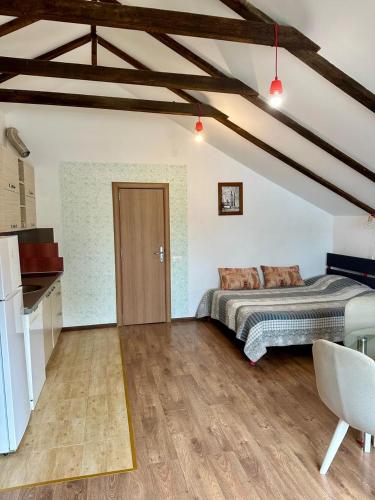 a bedroom with a bed and a wooden floor at Loft Studio in Igalo