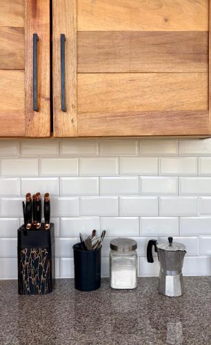 a kitchen counter with wooden cabinets and a container of utensils at Altos de Santa Catalina in Soná