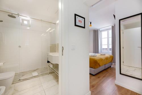 a bathroom with a shower and a toilet and a bed at Correio Velho Hotel in Lisbon