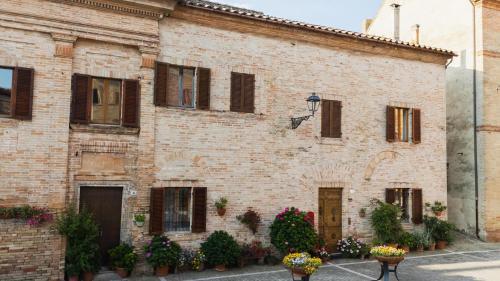 a brick building with flowers in front of it at Casa Montefiori in Montefiore dellʼAso