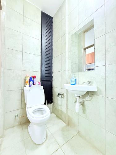 a white bathroom with a toilet and a sink at Neriah Paradise in Gatunga